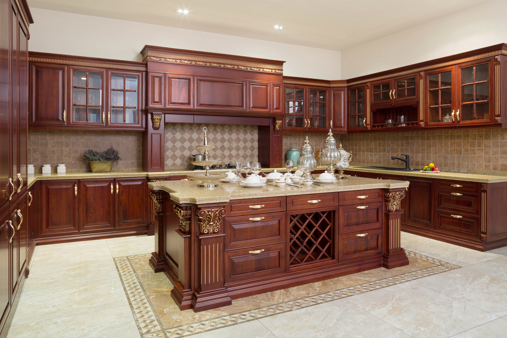 Luxury kitchen remodeling with rich wood cabinetry, large central island, and elegant tile backsplash.