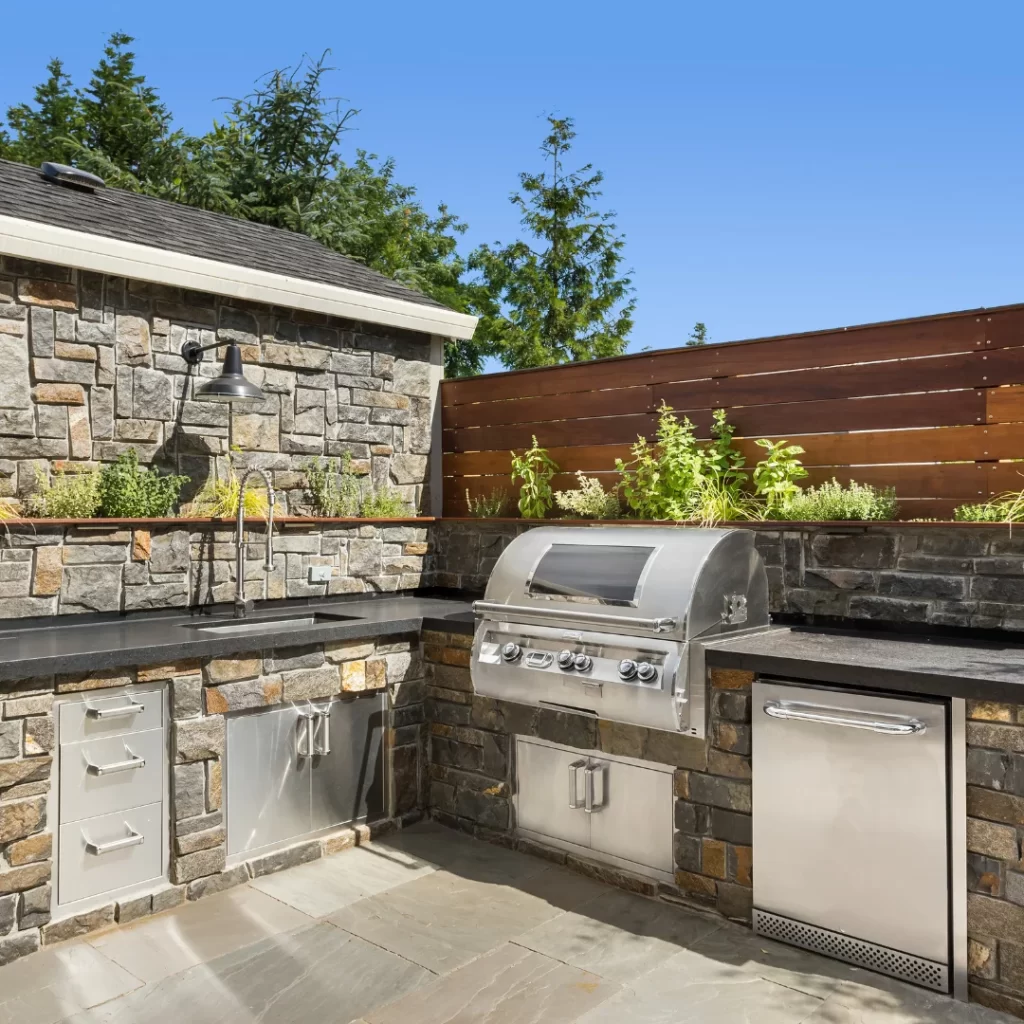 Modern outdoor kitchen remodeling with built-in grill, stainless steel appliances, and stone countertops.